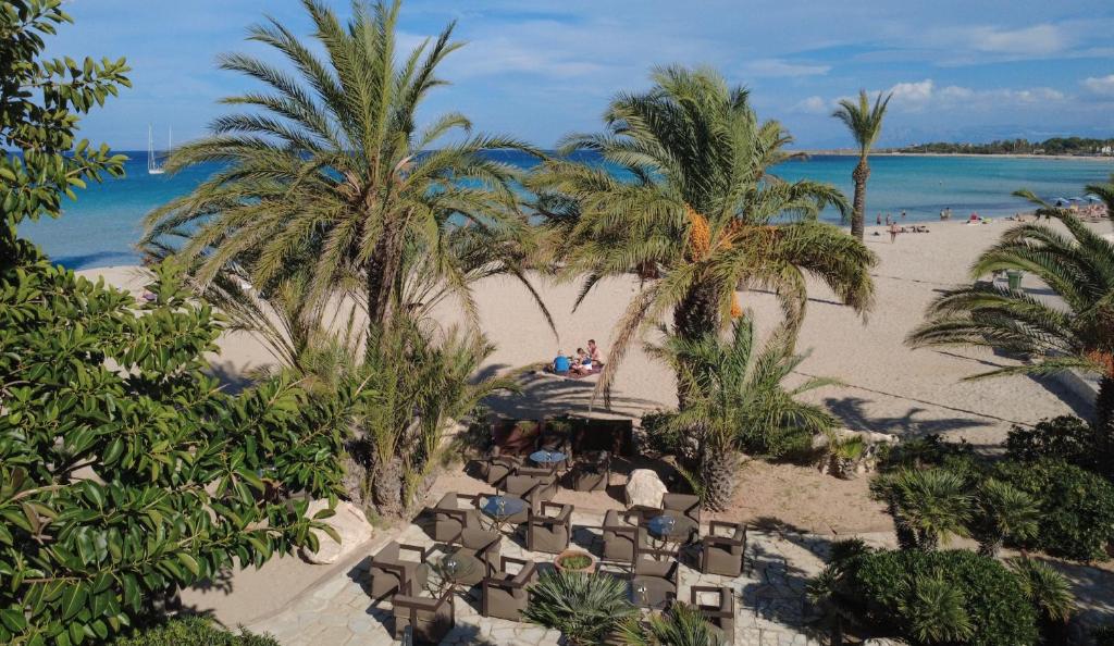 an aerial view of a beach with palm trees and chairs at Hotel Capo San Vito by Geocharme in San Vito lo Capo