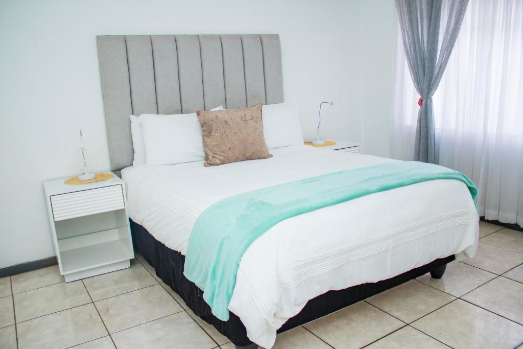 a bedroom with a bed with a blue and white blanket at 1 bed apartment in Harare CBD in Harare