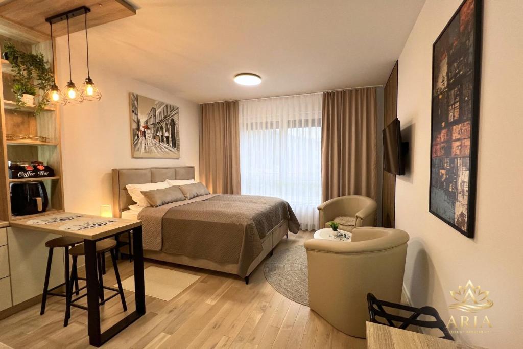 a hotel room with a bed and a table at ARIA Luxury Apartment, Tuzla in Tuzla