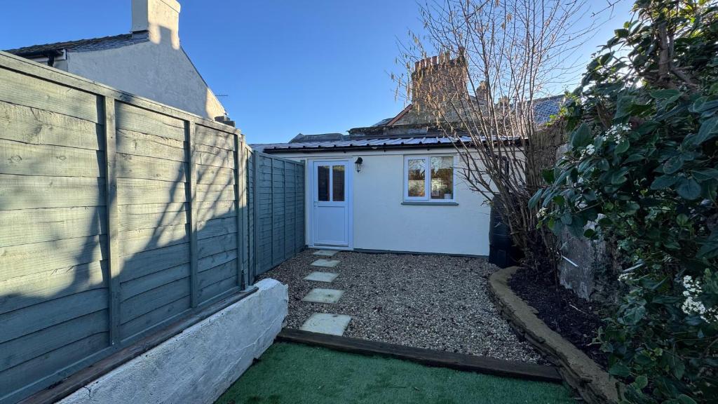 a small house with a white door next to a fence at The Hive in Bream