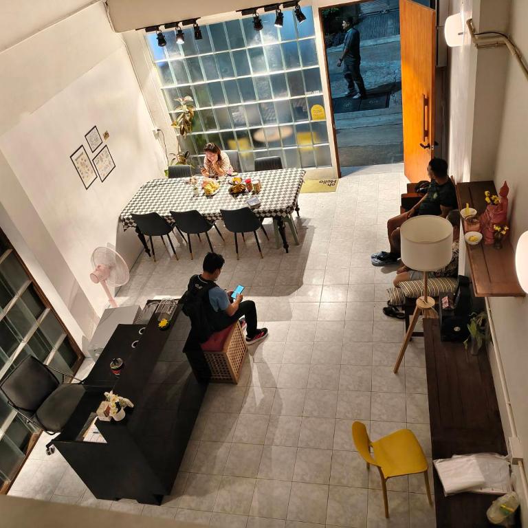 a group of people sitting around a table in a room at Zanit Hostel in Don Muang Airport