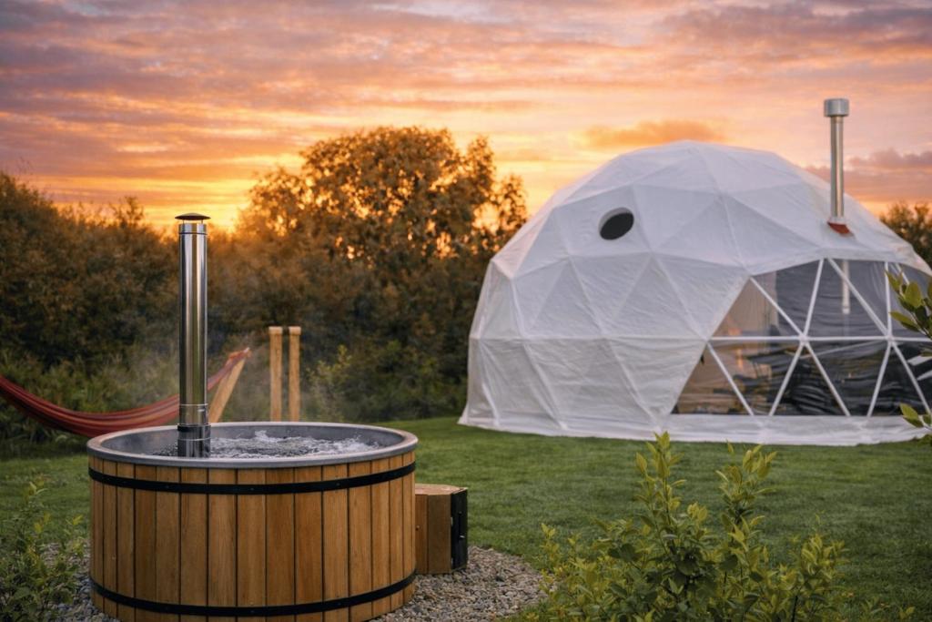 a tent with a hot tub in a field at Alpaca Hideaway in Llanstadwell