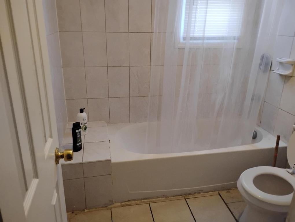 a bathroom with a tub and a toilet at Grove 125 in Irvington