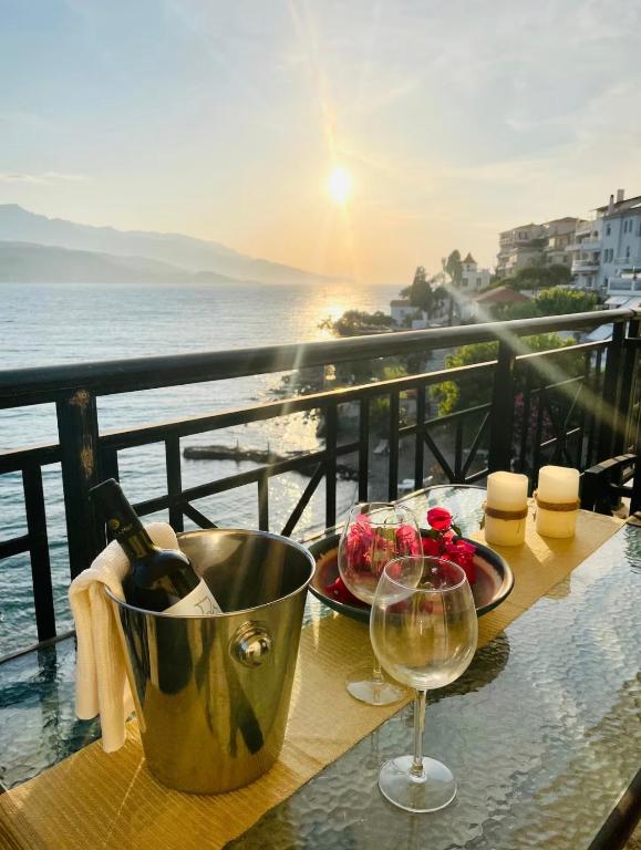 a table with a plate of food and a glass of wine at Seafront Central Luxury Apartment in Samos