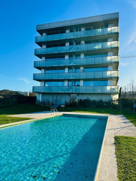 a building with a swimming pool in front of a building at Skyline Heaven - Fantastic View - Pool - Garage in Vila Nova de Gaia