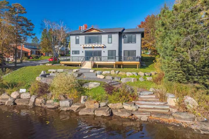 a large house with a pond in front of it at charming riverside retreat in Huntsville