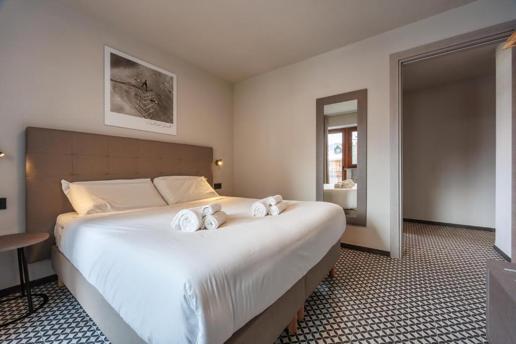 a bedroom with a large bed with towels on it at Central Guest in Sauze dʼOulx