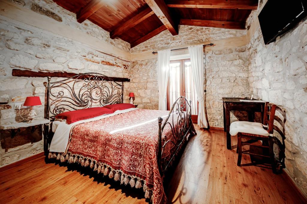 a bedroom with a bed in a stone wall at B&B Lo Gnomo in Pennapiedimonte