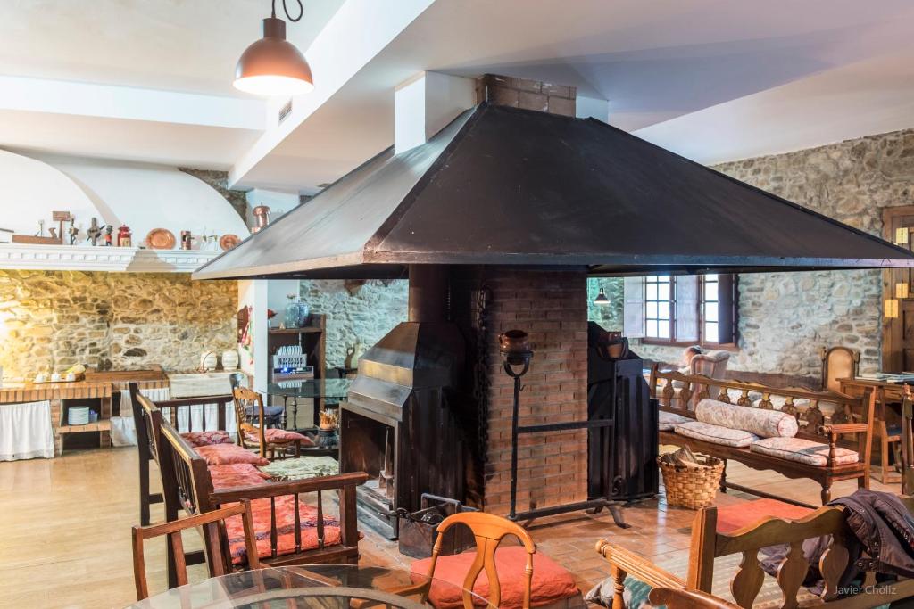 een grote open haard in een kamer met tafels en stoelen bij La Casa Del Reloj in Molinaseca