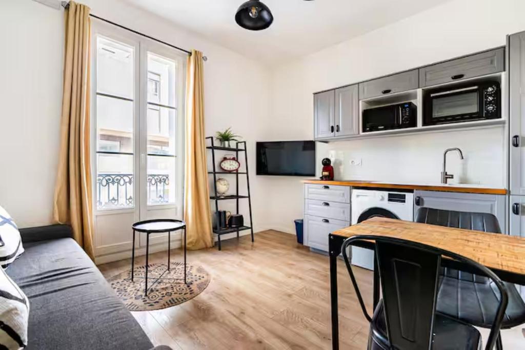 a living room with a table and a kitchen at Comédie ST-Roch - T2 - Hypercentre Gare - CLIM & NETFLIX in Montpellier