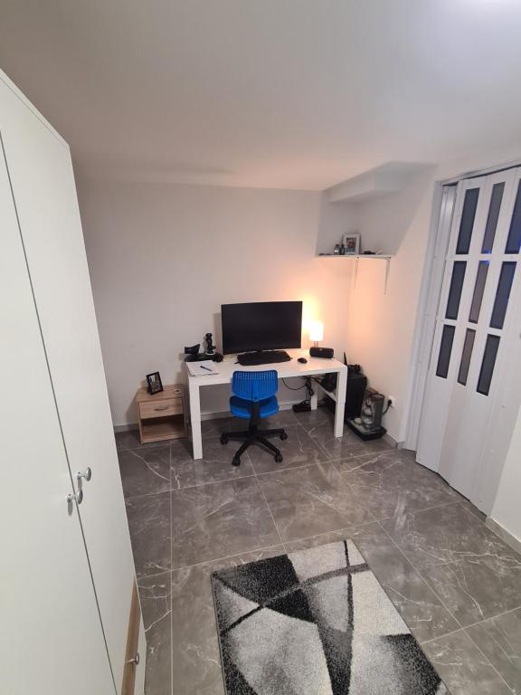 an office with a white desk and a blue chair at Villa basement Apartment in Ennigerloh
