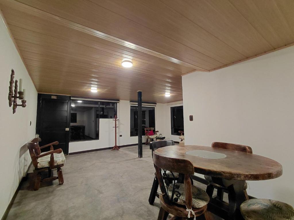 a living room with a wooden table and chairs at Refugio rural MITA in Zipacón