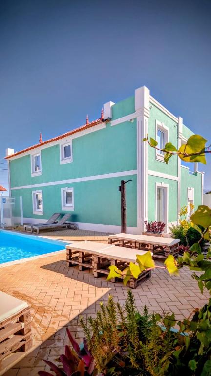 a building with a picnic table and chairs next to a pool at Casa do Castelo in Gafanha da Nazaré