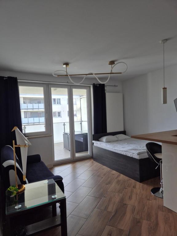 a bedroom with a bed and a desk and a couch at Apartament Golden Flight in Warsaw