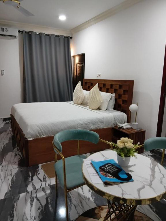 a bedroom with a bed and a table and chairs at First HR Hotel in Prampram