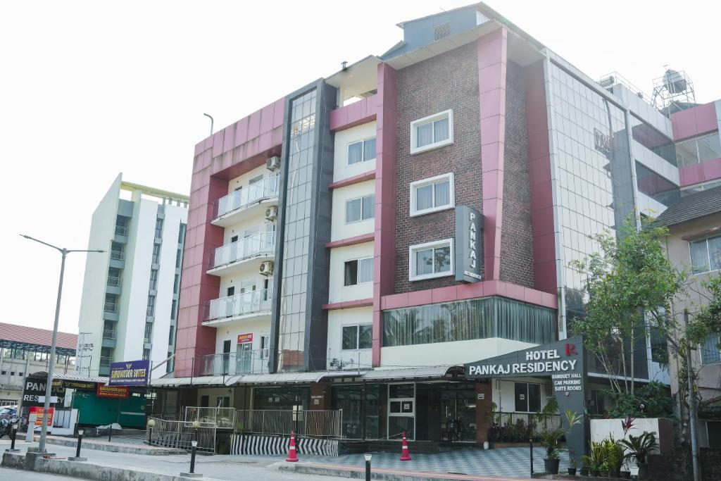 a pink building on the side of a street at krishna suites guruvayur in Guruvāyūr