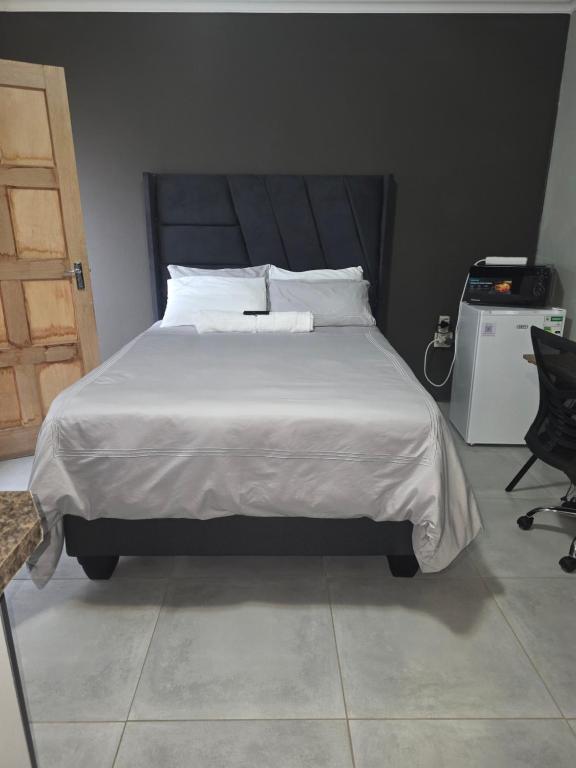 a bed with white sheets and pillows in a bedroom at The Good Samaritan 1 in eMalahleni