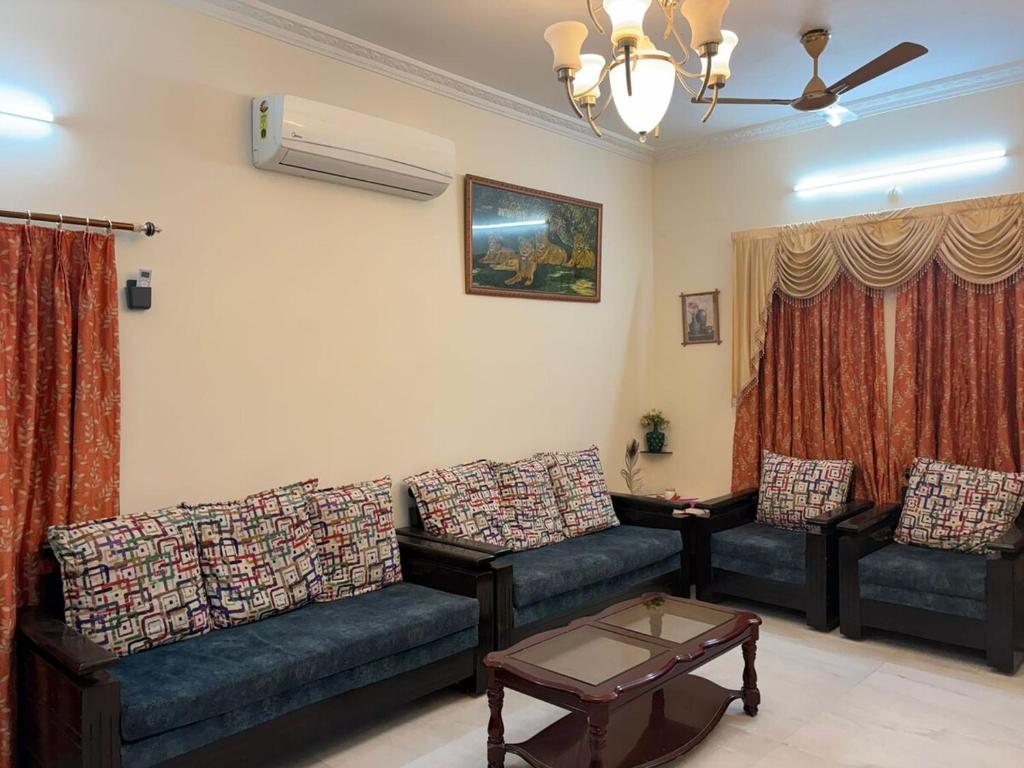 a living room with two couches and a coffee table at Naidu Villa in Secunderabad