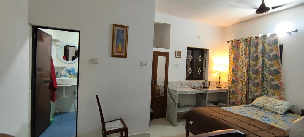 a bedroom with a bed and a bathroom with a sink at Minx guest house in Candolim