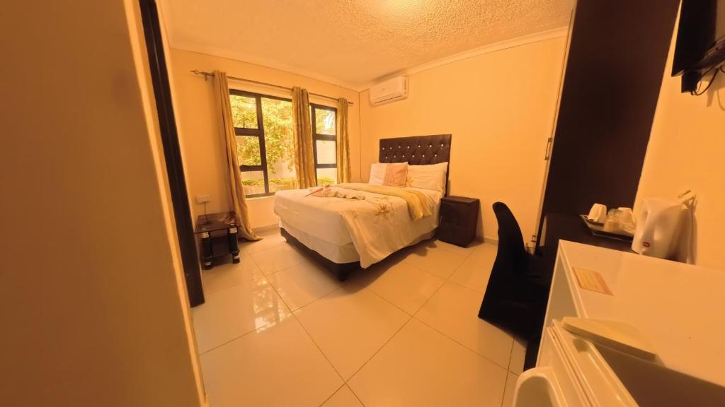 a bedroom with a bed and a window at Kings Rest Bed And Breakfast in Gaborone