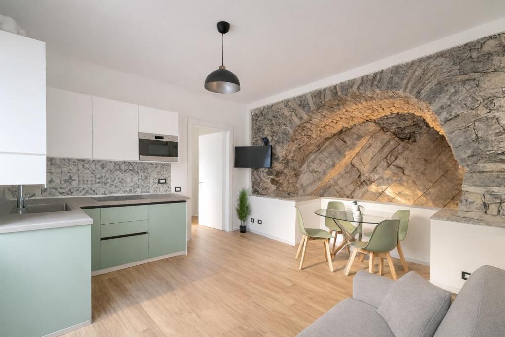a kitchen and living room with a stone wall at Como Lake View in Brienno