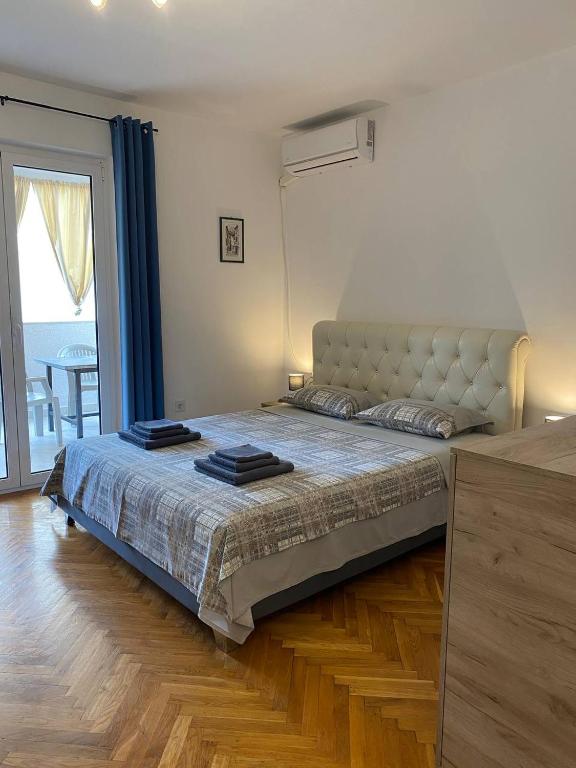 a bedroom with a large bed and a large window at Alina's apartment in Bečići