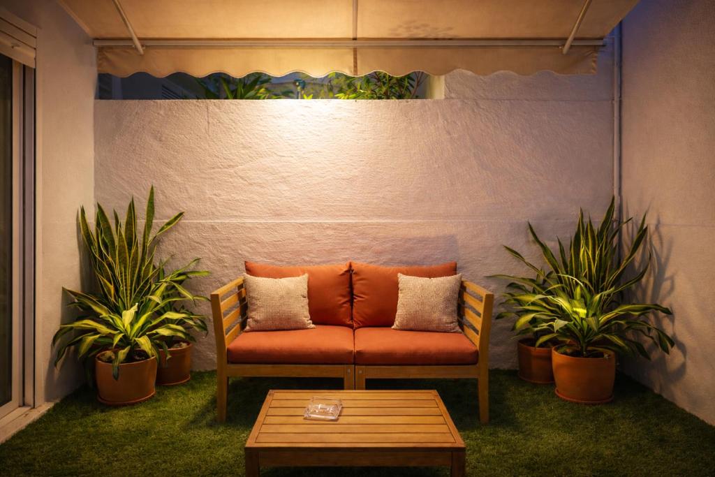 an orange couch in a room with two plants at Sofia Luxury Apartment in Seville