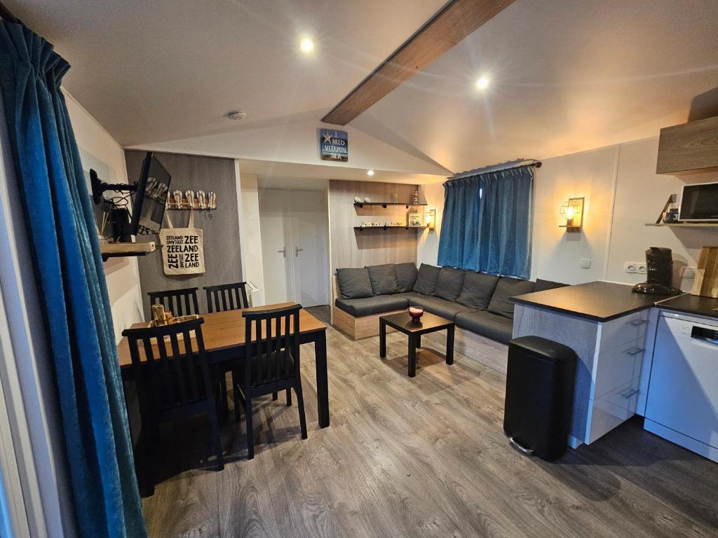 a living room with a couch and a table at Chalet First Stage - Renesse in Renesse