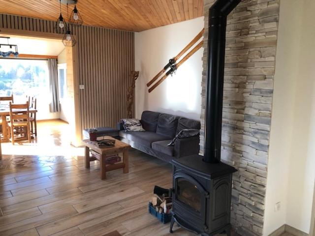 a living room with a fireplace and a couch at Chalet Belfahy in Belfahy