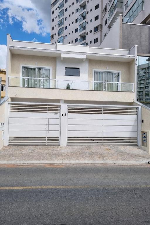 a white house with a white garage door at Apartamento da Adriana in Itajubá