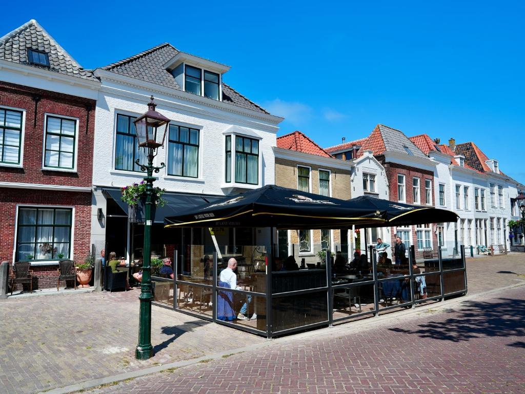 a cafe with an umbrella on a city street at Zen Kitchen & Boutique Hotel in Brouwershaven