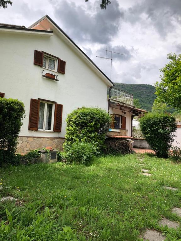 a house with a green yard in front of it at Una casa ospitale con giardino in Castel SantʼAngelo