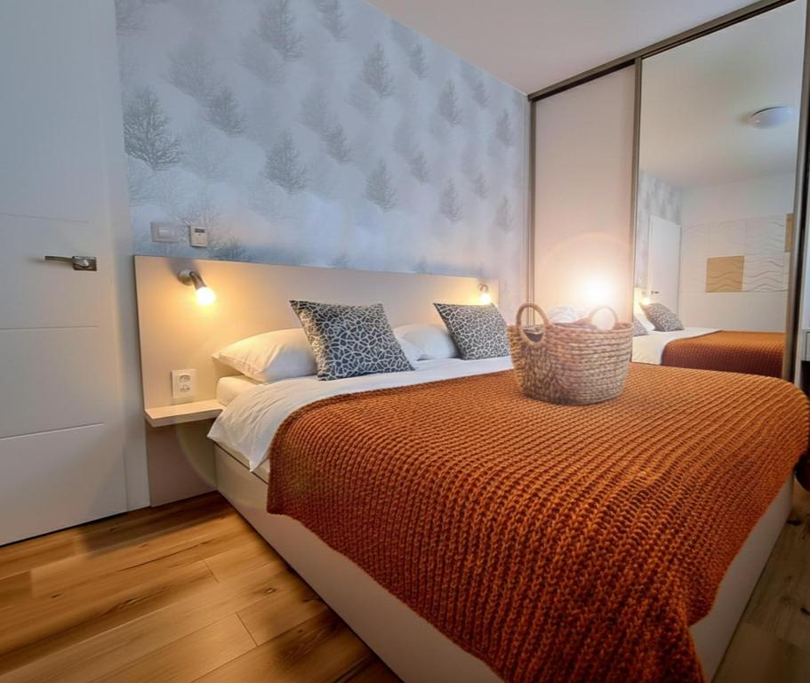 a bedroom with a large bed with an orange blanket at Apartmán Nad Arénou NMNM in Nové Město na Moravě