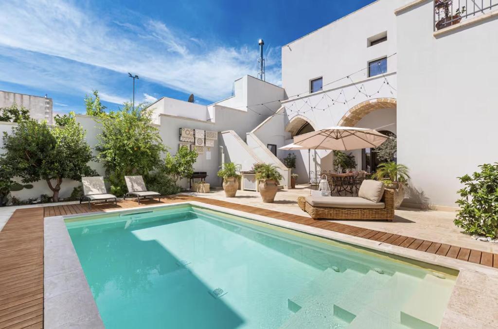 a swimming pool in front of a house at Palazzo Flora in Collepasso