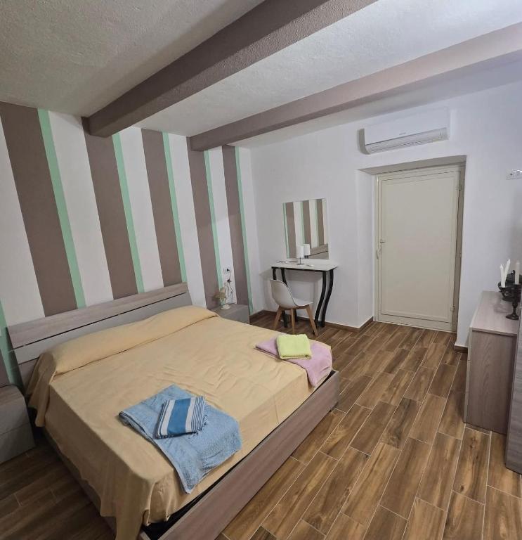 a bedroom with a large bed and a desk at La Nicchia Del Borgo in Badolato