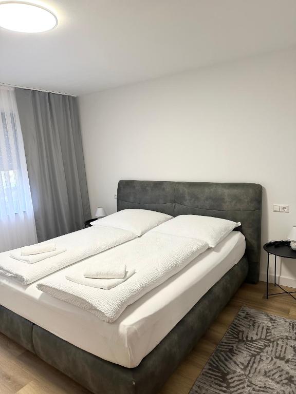 a bedroom with a large bed with white sheets at Ferienwohnung am Wildpark Eichert HDH in Heidenheim an der Brenz