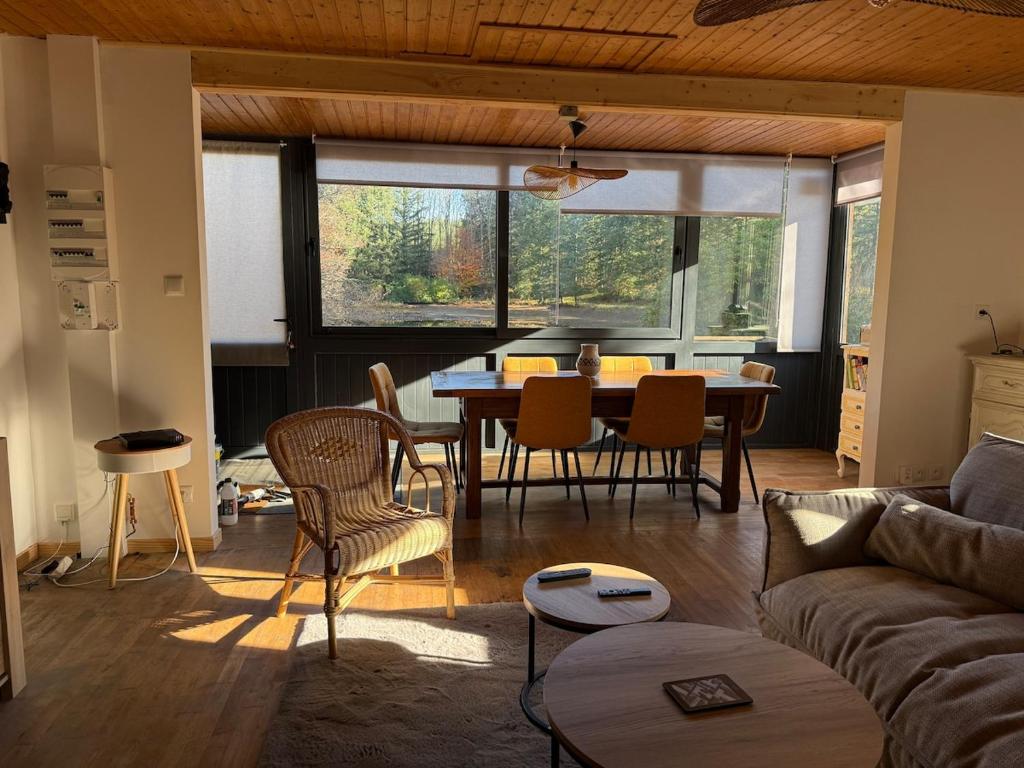 a living room with a table and chairs at Chalet dans la nature in Palisse