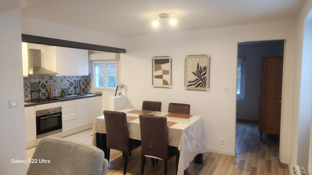 eine Küche und ein Esszimmer mit Tisch und Stühlen in der Unterkunft GITE kass immo in Culmont