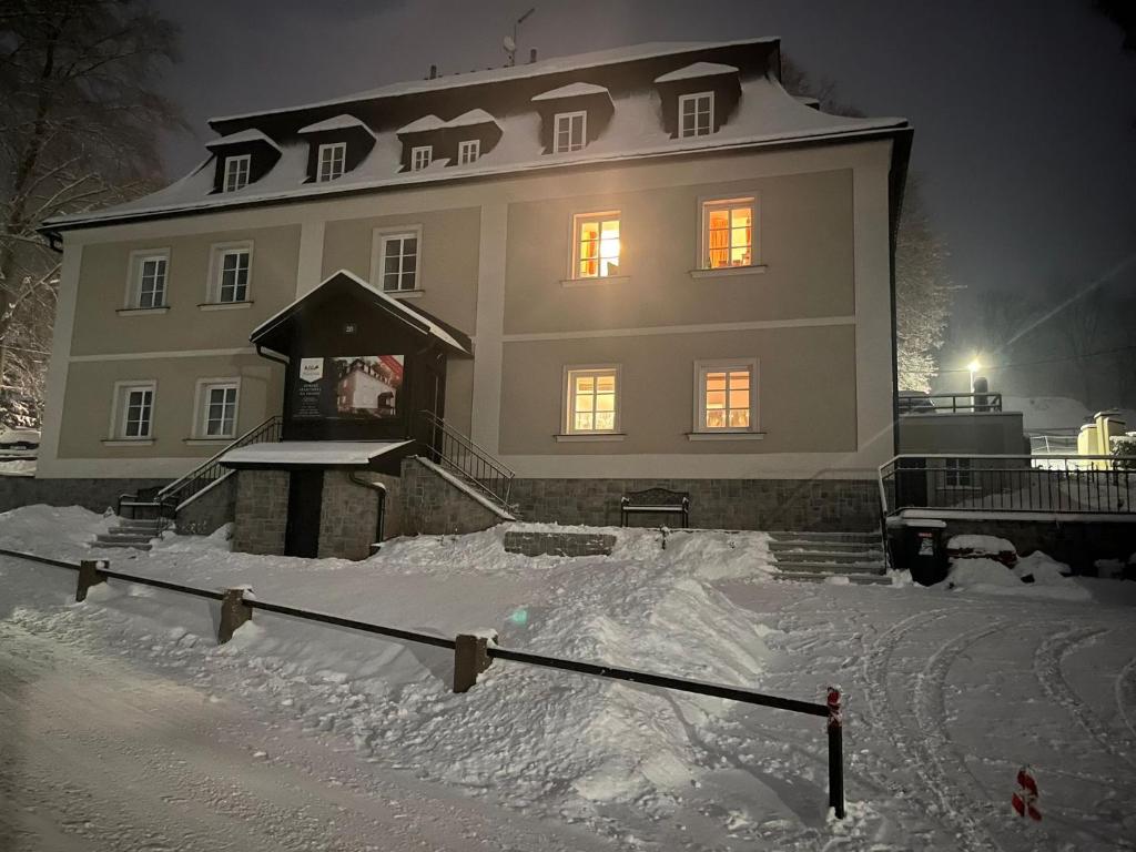 a large house with snow in front of it at Útulný apartmán Vitkovice in Vítkovice