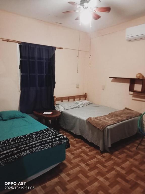 a bedroom with two beds and a ceiling fan at Casa de ámbar cuatunalco in Cuatunalco