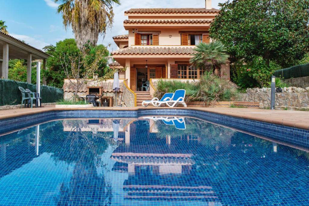 a house with a swimming pool in front of a house at Villa Ficus in Lloret de Mar