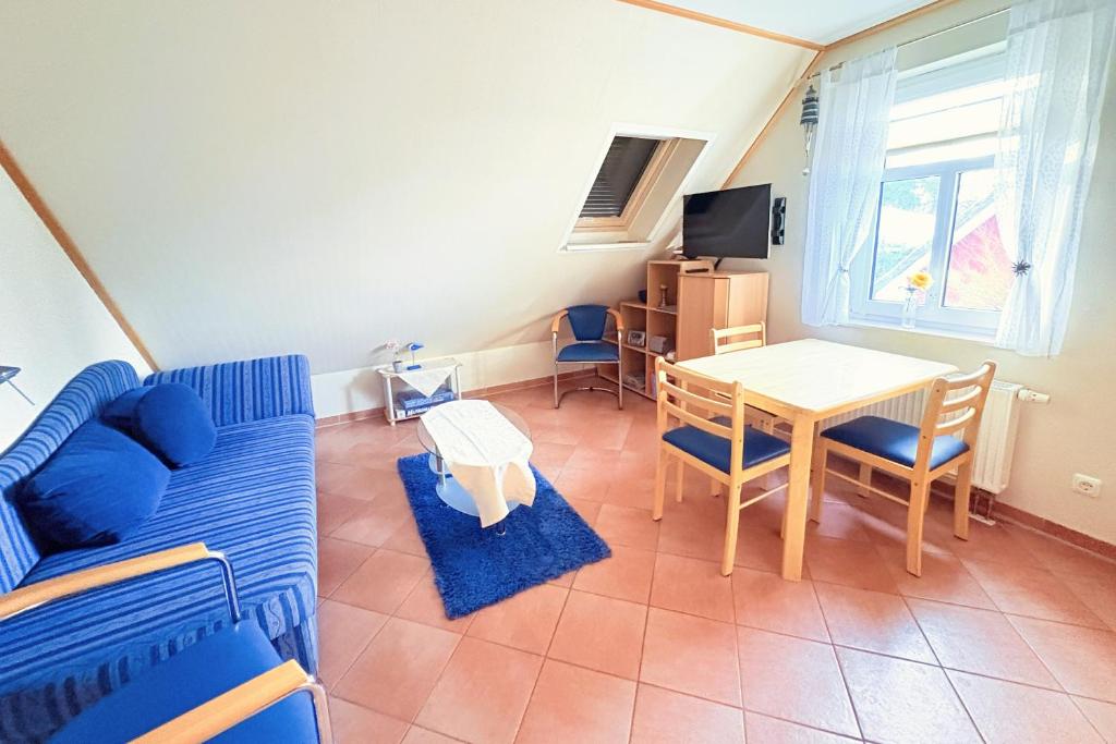 a living room with a blue couch and a table at Ferienwohnung Flieder - ruhig und tierfreundlich in Mariendorf