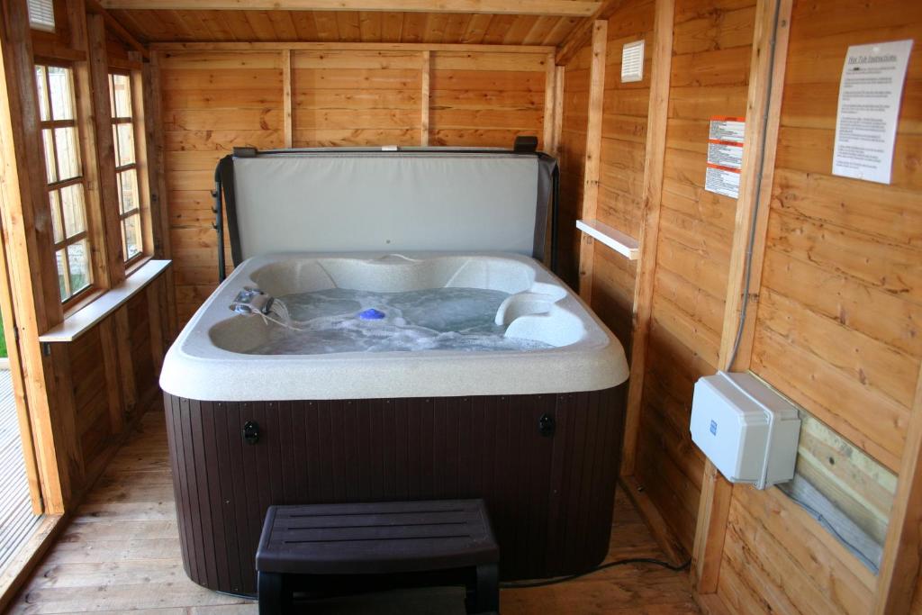 a jacuzzi tub in a wooden cabin at Swn y Mor (Sound of the Sea) in Prestatyn