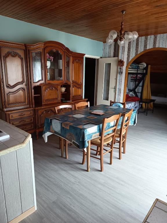 a dining room with a table and wooden furniture at Chez Sylvia in Saint-Julien-du-Pinet