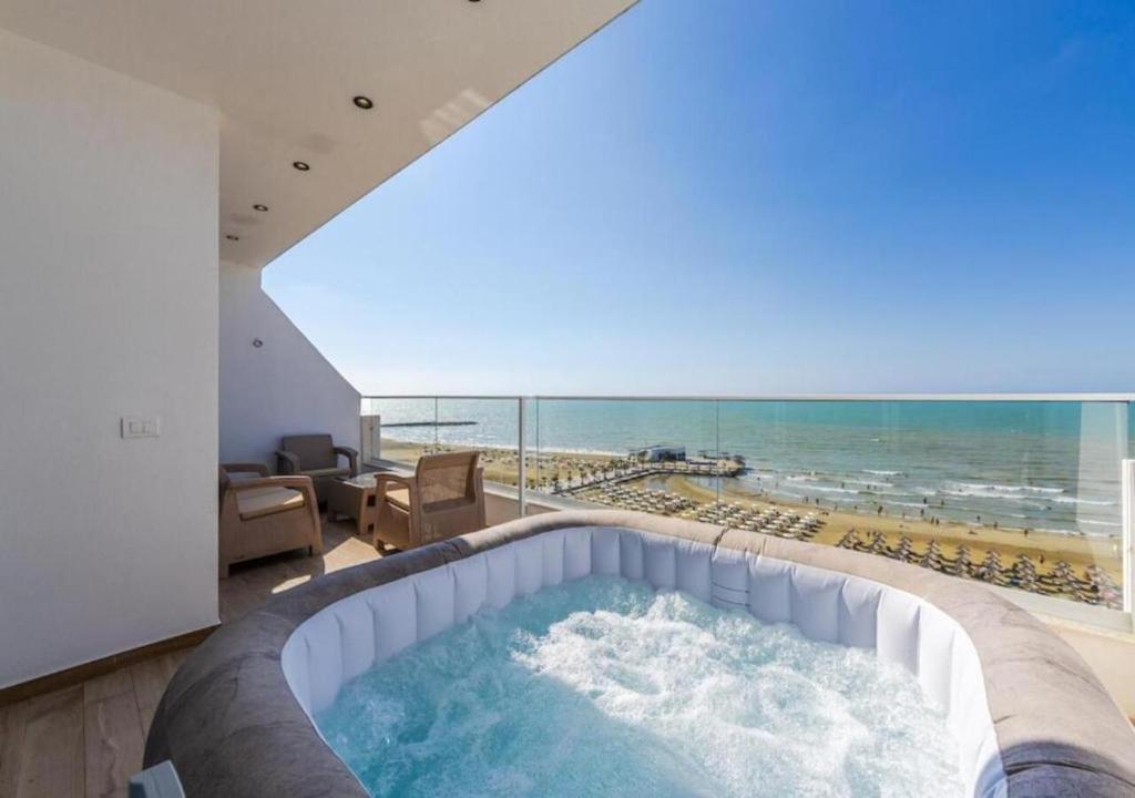 a hot tub in a room with a view of the beach at The Seaview Jacuzzi Suite by PS in Golem