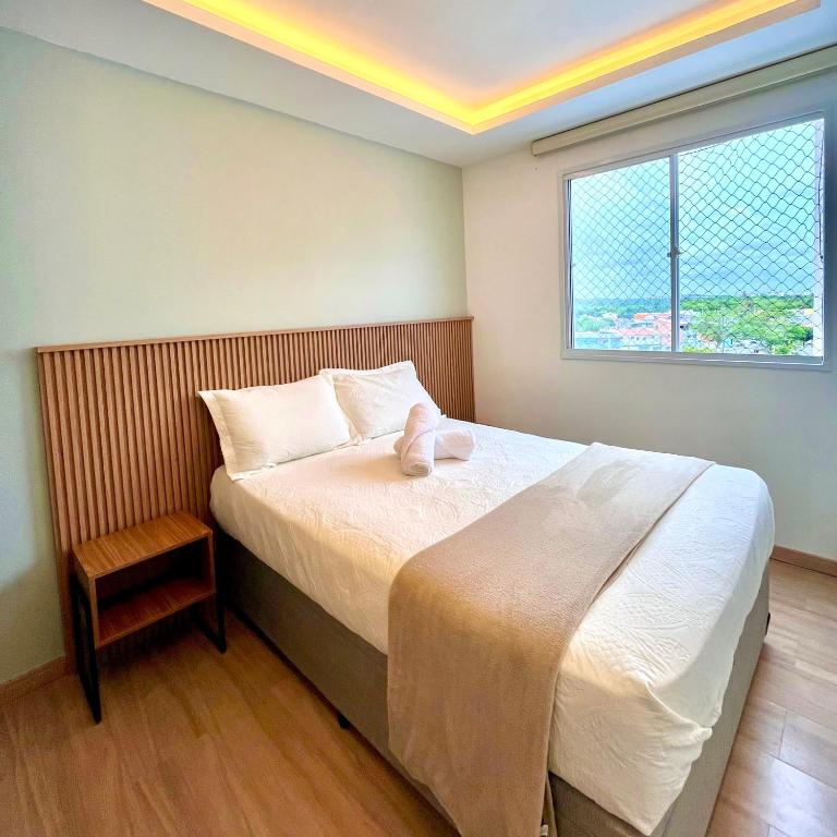 a bedroom with a bed and a window at Solar Aruana, Aracaju, Aeroporto, Orla de Atalaia e Praia in Aracaju