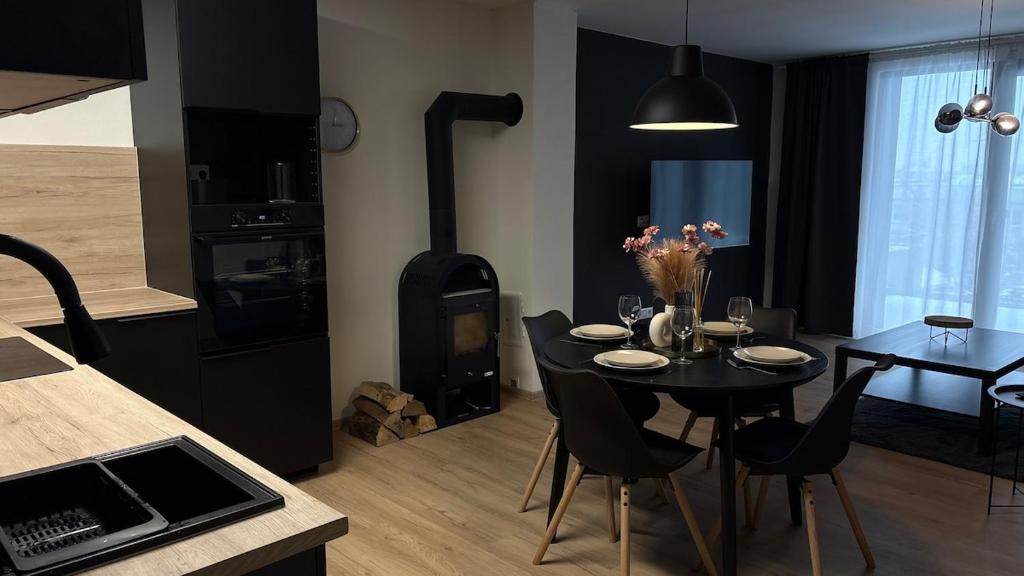a kitchen and dining room with a table and a stove at Apartmán Jungmannka in Bruntál
