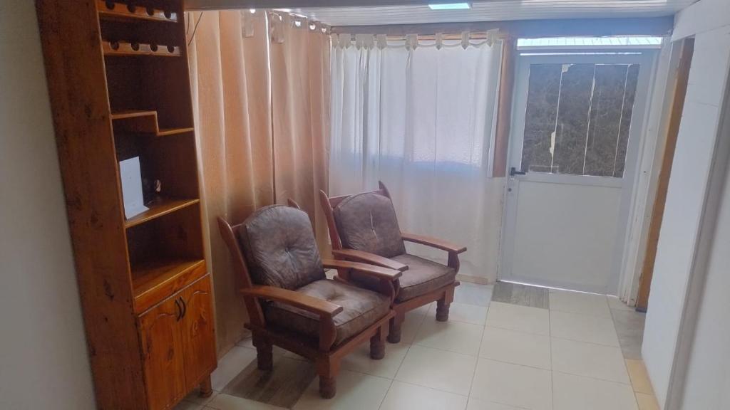 two chairs in a room with a tv and a window at Cabaña Mailin II in Uspallata