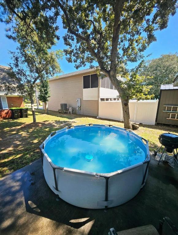 a bath tub sitting in a yard next to a tree at Pool, Blocks away from Beach, Dog friendly in Oak Island