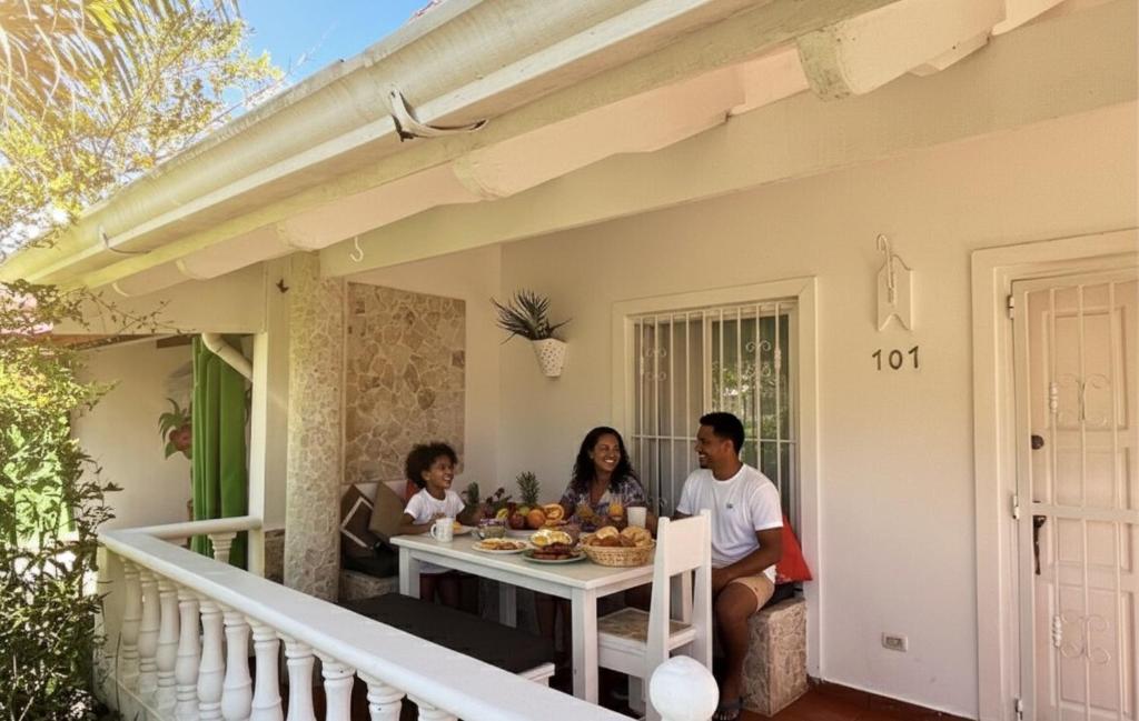 a group of people sitting at a table on a porch at Habitat Samaná Apartments - Coral Samanà in Los Corozos